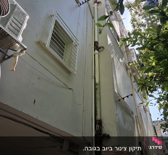 צנרת חיצונית על קיר בניין עם מזגנים